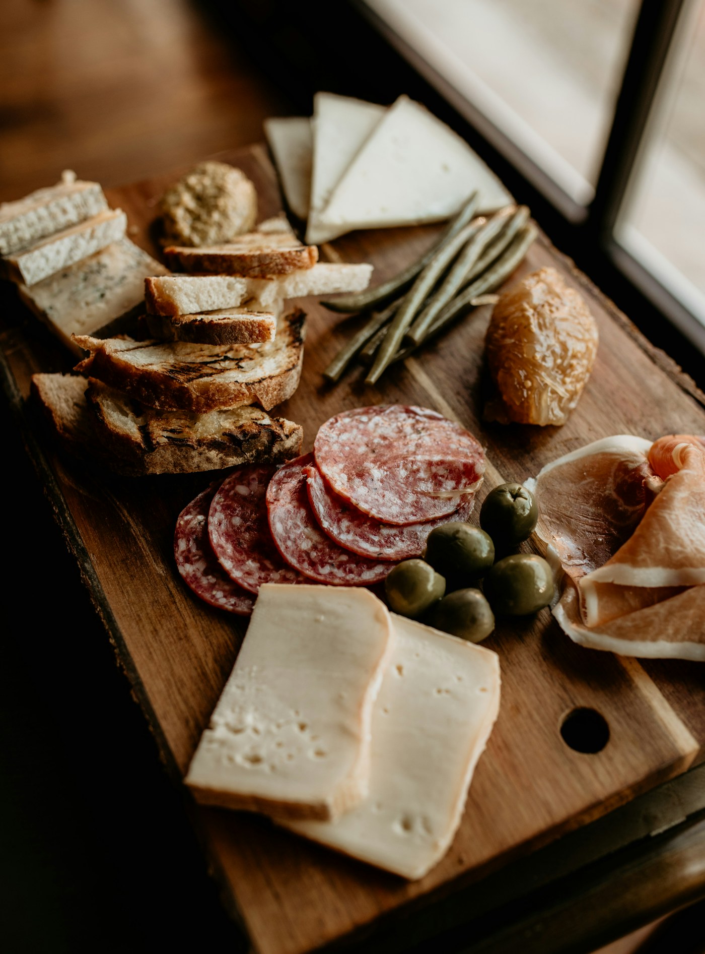 Tapasplank met vleeswaren, kaas, olijven en brood